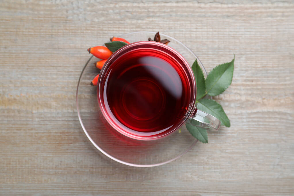 Aromás csipkebogyó tea és friss bogyós fa asztal, felülnézet - Fotó, kép