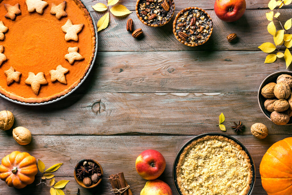 白い木製の背景に感謝祭の秋のパイ、コピースペース。秋の休日のための秋の自家製カボチャ、リンゴとピーマンパイと成分. - 写真・画像