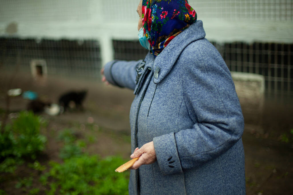 Een oude vrouw in Rusland. Gepensioneerde in een jas op straat. Een vrouw met een hoofddoek op haar hoofd.. - Foto, afbeelding