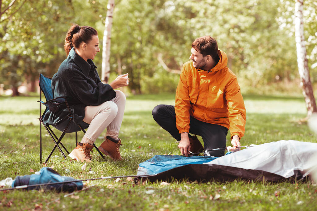 happy couple setting up tent outdoors - Photo, Image