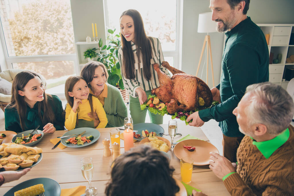 Photo de douce famille excitée prêt à manger dinde de vacances souriante table assise à l'intérieur salle de la maison - Photo, image