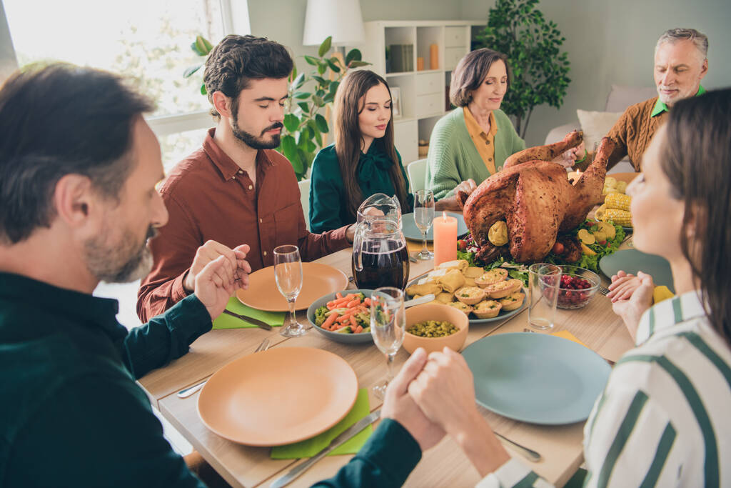 Photo of charming dreamy family celebrating thanks giving day sitting table holding arms praying indoors room home - Photo, Image