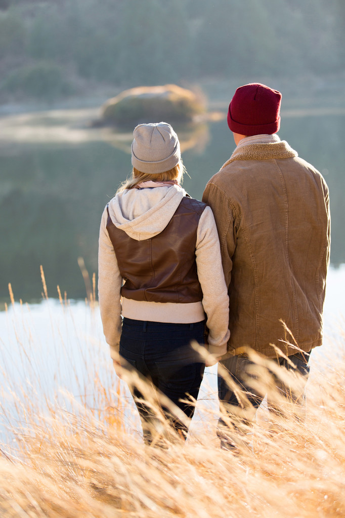 joven pareja de pie junto al lago
 - Foto, Imagen