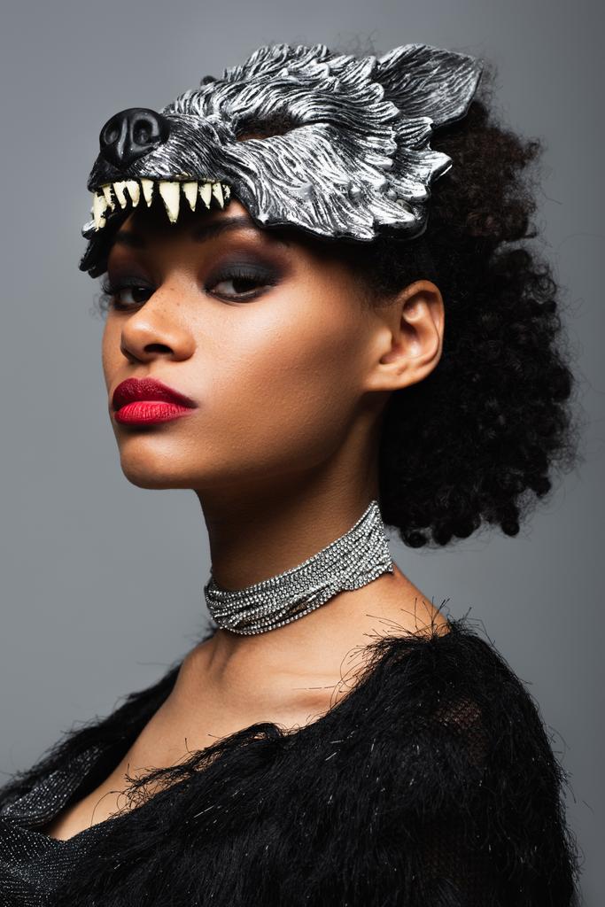 アフリカ系アメリカ人の女性が狼ハロウィンマスクと金属製のネックレスに自信を持って - 写真・画像