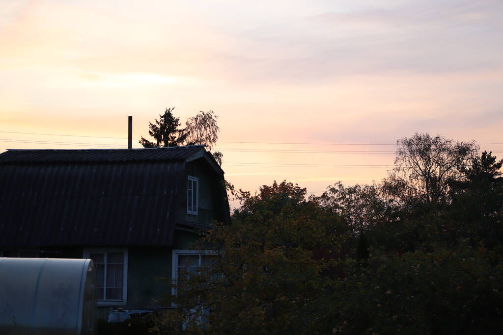 Aussicht, die man nur aufs Land bekommt - schöner Sonnenuntergang vom Dorfhausdach - Foto, Bild