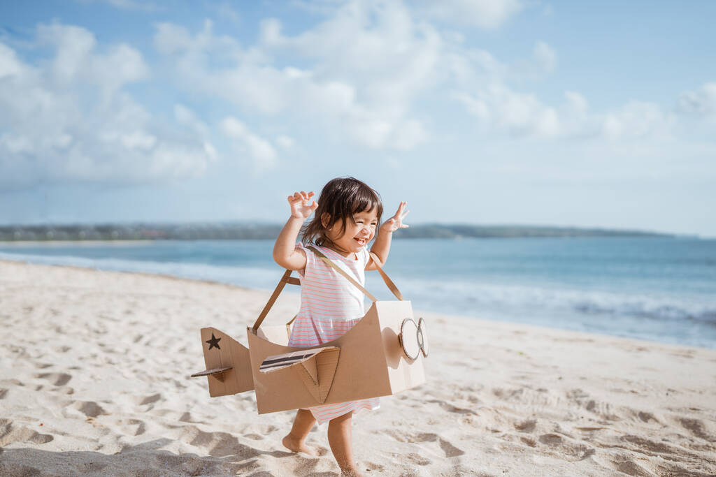 lapsi ajaa rannalla pelata lelu lentokone on valmistettu pahvista - Valokuva, kuva