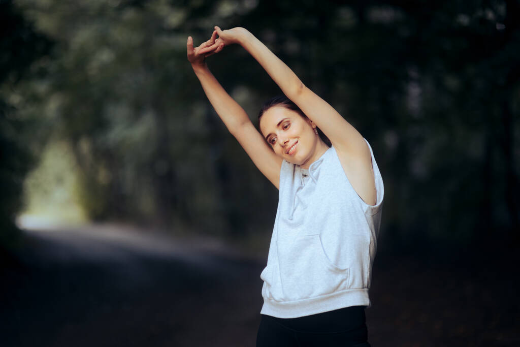 Спортивна жінка розтягує руки перед бігом
  - Фото, зображення