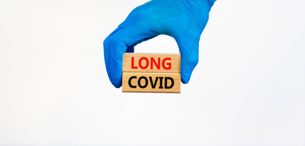 COVID-19 világjárvány hosszú kovid szimbólum. Orvos kéz a kék kesztyű tartja fa blokkok szavakkal hosszú, tömör, gyönyörű fehér háttér. Orvosi, COVID-19 világjárvány hosszú kovid koncepció. - Fotó, kép