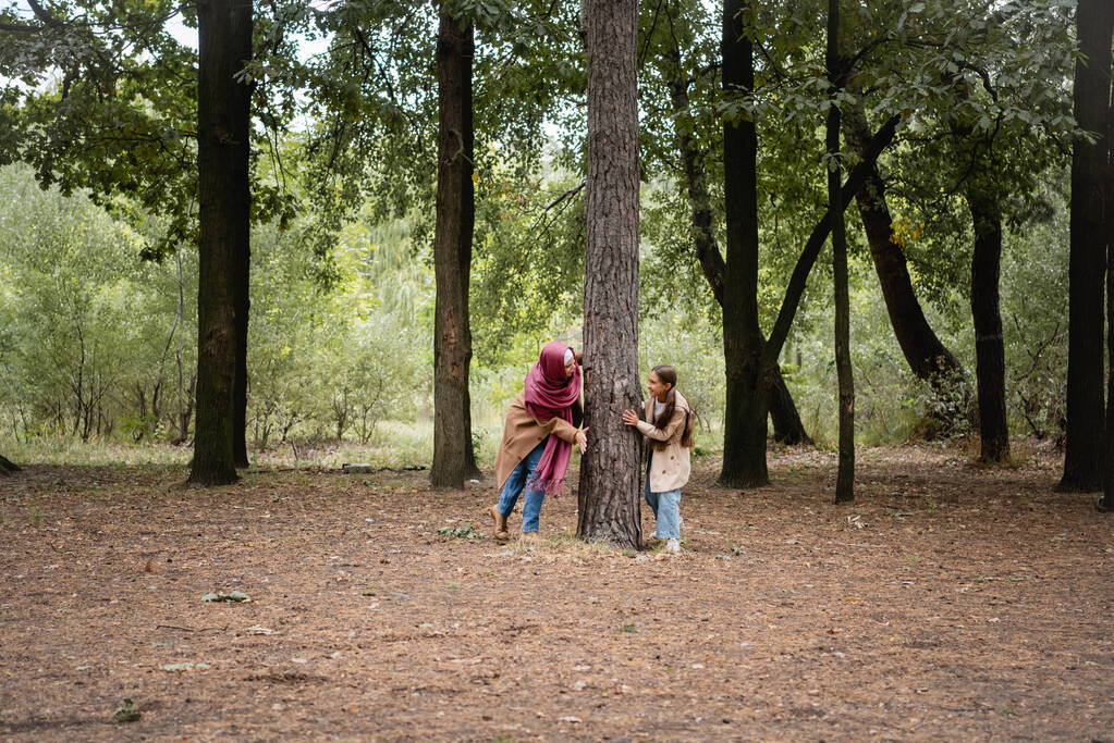 Gülümseyen Müslüman kız parkta annesiyle oynuyor.  - Fotoğraf, Görsel