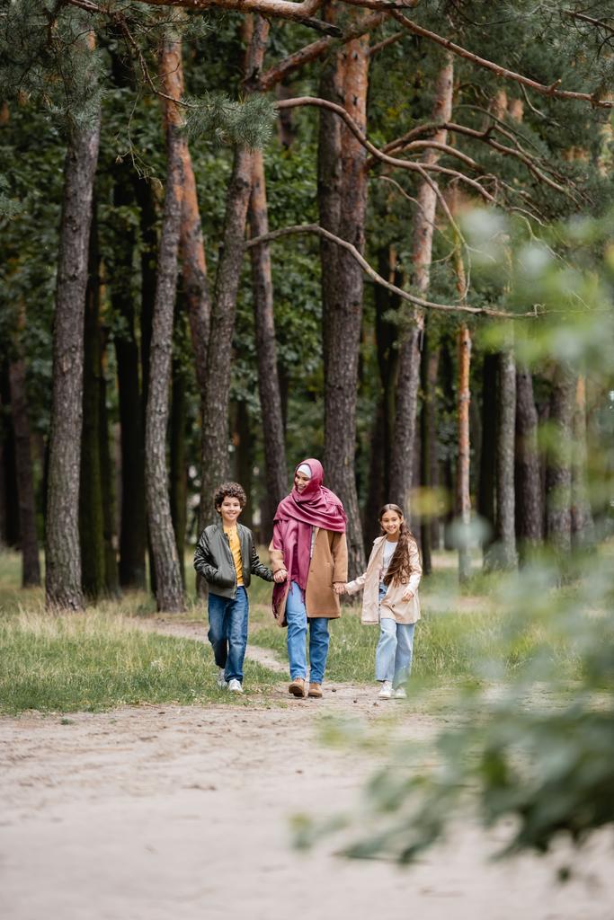 Восени арабська мати ходить з дітьми в парку.  - Фото, зображення