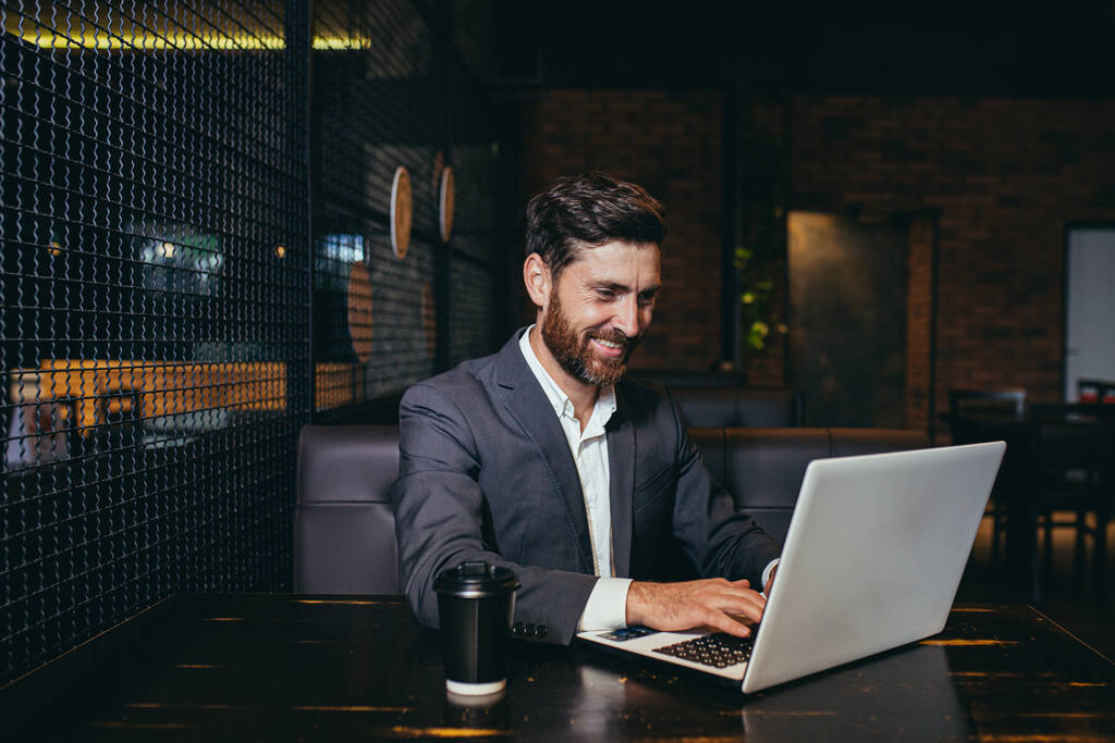 Úspěšný podnikatel pracující na notebooku během přestávky na oběd sedí v hotelové restauraci - Fotografie, Obrázek