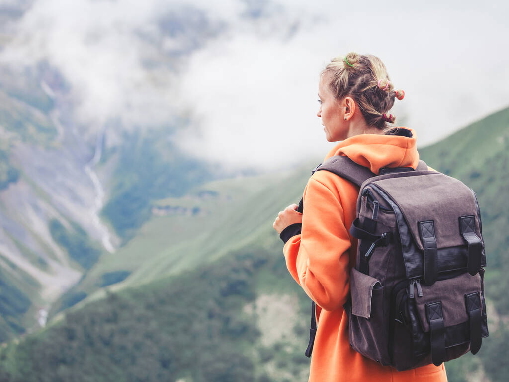 Człowiek w górnej części góry. Turystyczna kobieta z plecakiem w górach - Zdjęcie, obraz