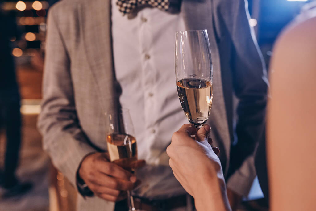 Close-up of well dressed couple holding champagne flutes - Photo, Image