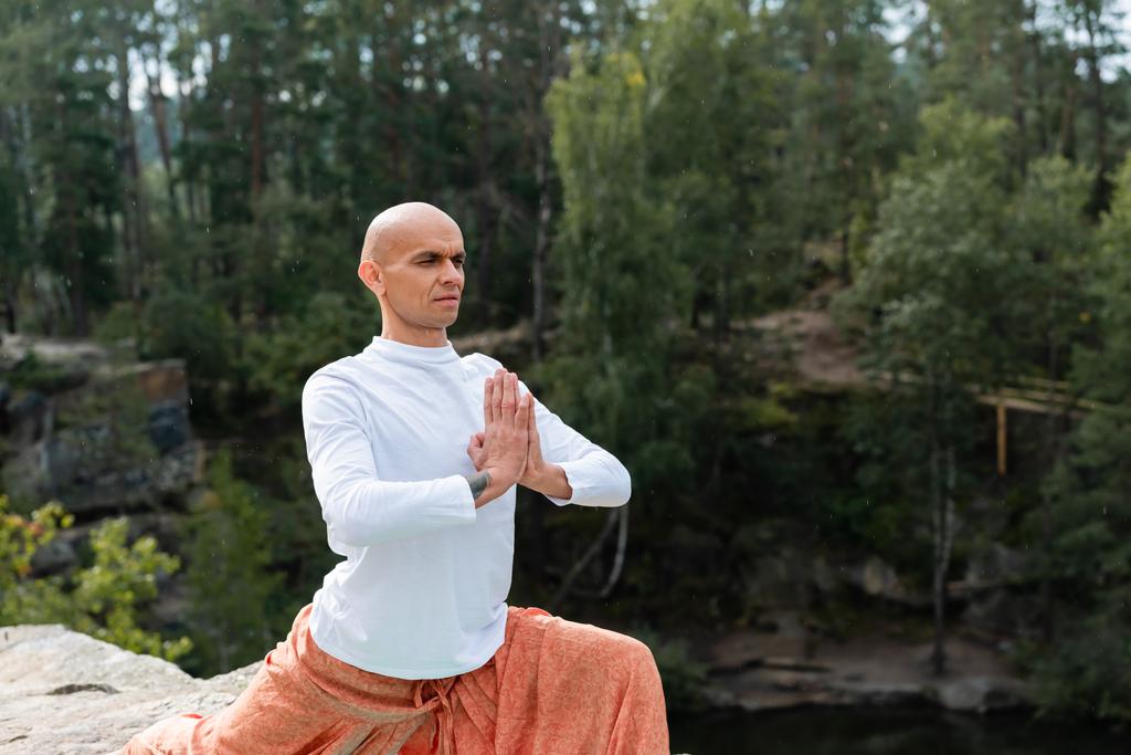 buddhista visel fehér pulóver gyakorló jóga póz imádkozó kéz az erdőben - Fotó, kép