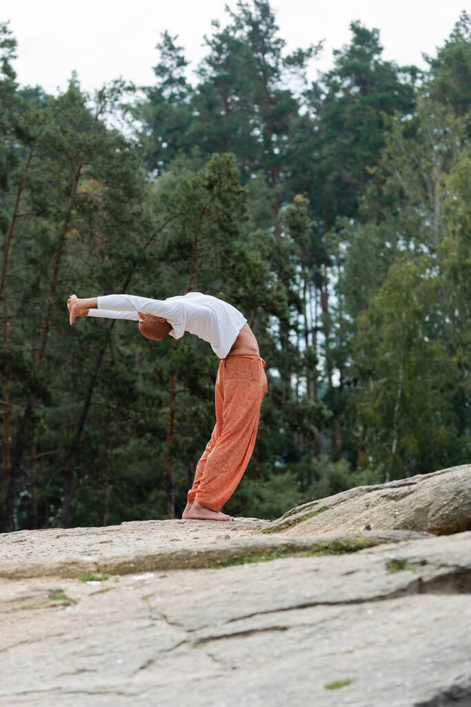 vista completa de la postura budista meditando en la curva hacia atrás en el bosque - Foto, Imagen