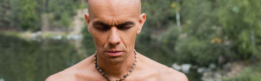 buddista senza maglietta in perline meditando con gli occhi chiusi all'aperto, banner - Foto, immagini
