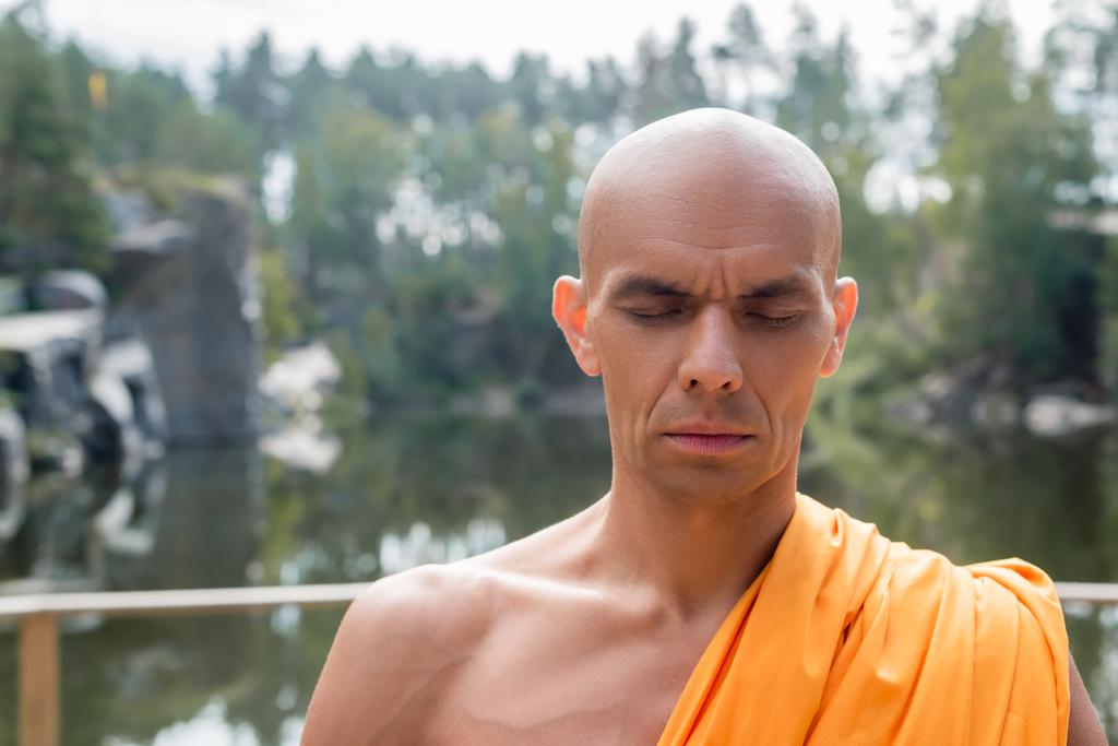 monje budista rezando con los ojos cerrados al aire libre - Foto, Imagen