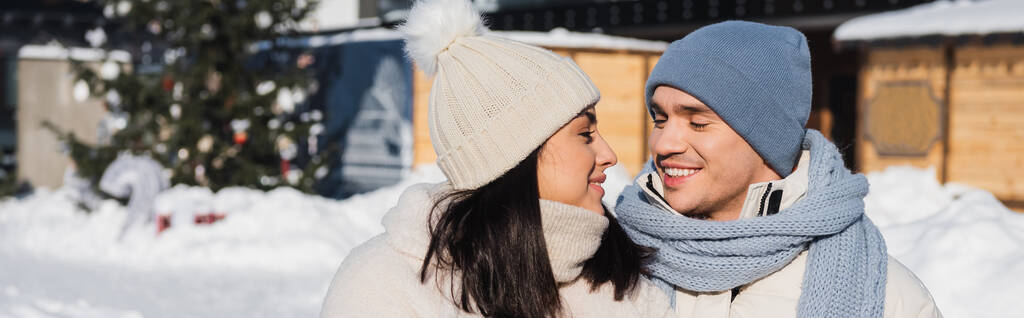 heureux homme et femme en bonnets tricotés se regardant, bannière - Photo, image