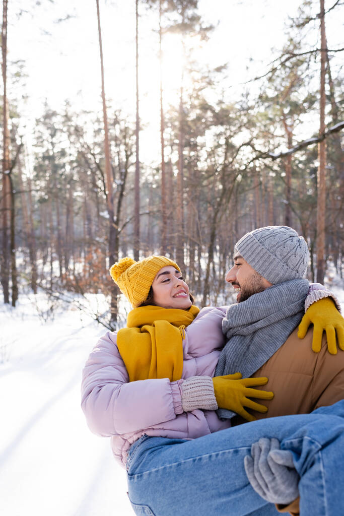 Usmívající se muž zvedání přítelkyně v zimním parku  - Fotografie, Obrázek