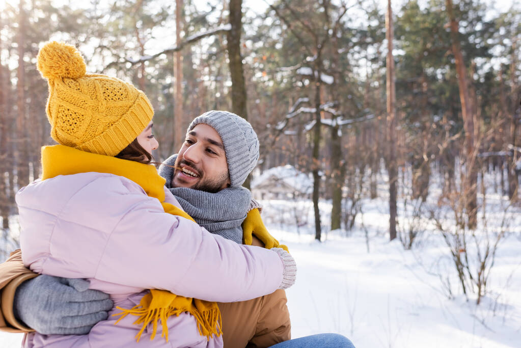 Sorrindo homem abraçando namorada em chapéu de malha no parque de inverno  - Foto, Imagem