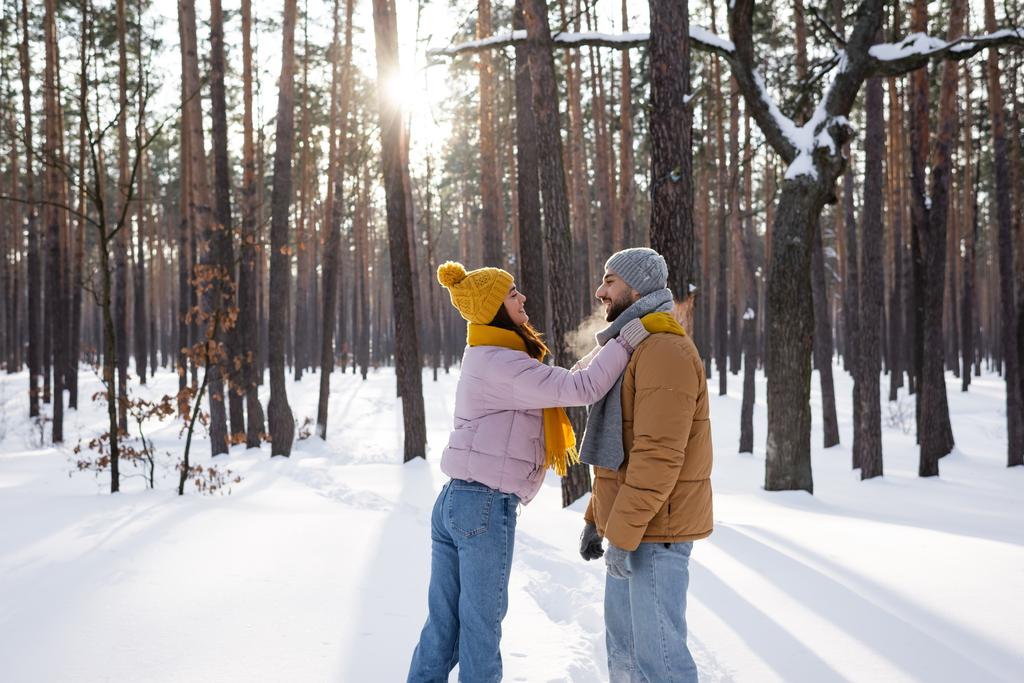 側ビューの明るいです女性受け入れボーイフレンドで雪の公園  - 写真・画像