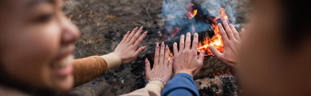 Blurred couple warming hands near campfire, banner  - Photo, Image