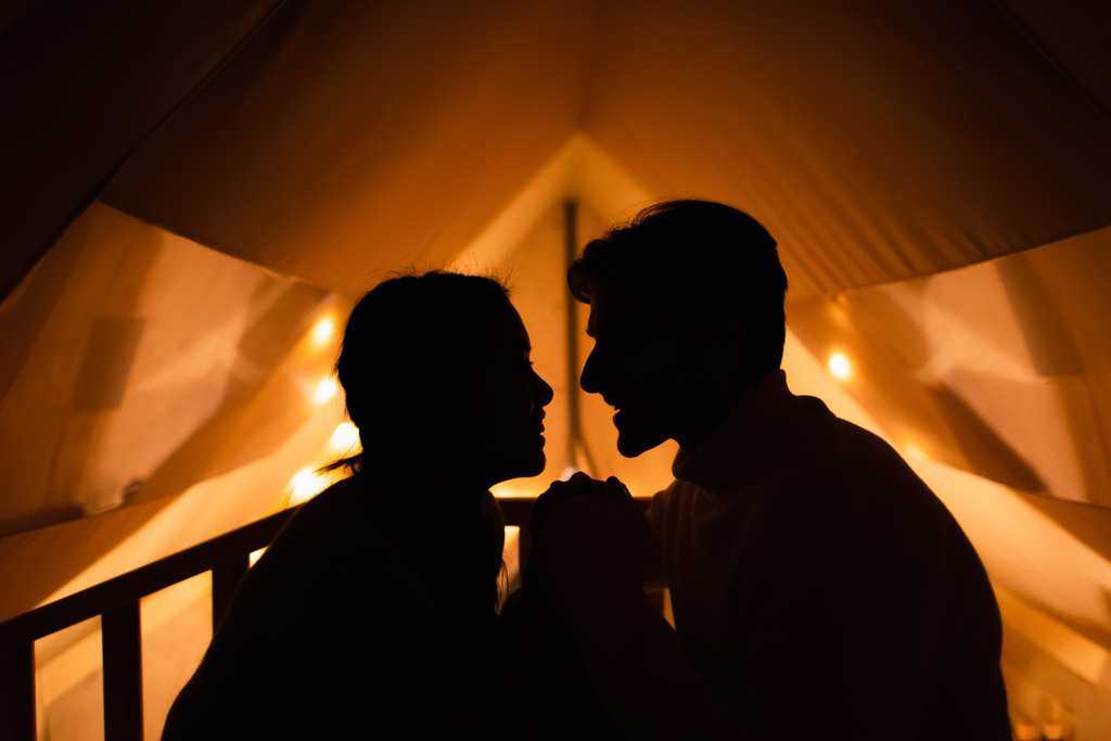 Zijaanzicht van silhouet van paar in glamping house  - Foto, afbeelding