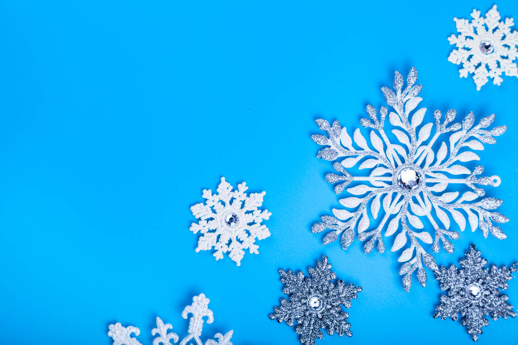 Νιφάδες χιονιού σε μπλε φόντο. Χριστουγεννιάτικη διακόσμηση. Θέση για το κείμενο σας. - Φωτογραφία, εικόνα