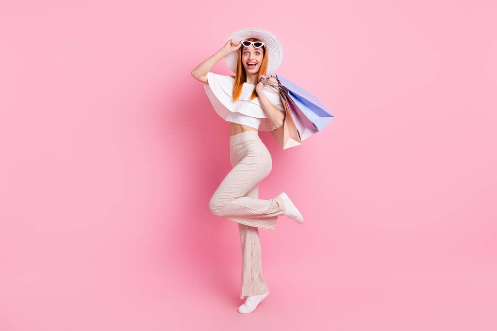 Full length φωτογραφία του ελκυστική νεαρή γυναίκα κατάπληκτος καλή shopper διάθεση απομονώνονται σε παστέλ ροζ φόντο χρώμα - Φωτογραφία, εικόνα