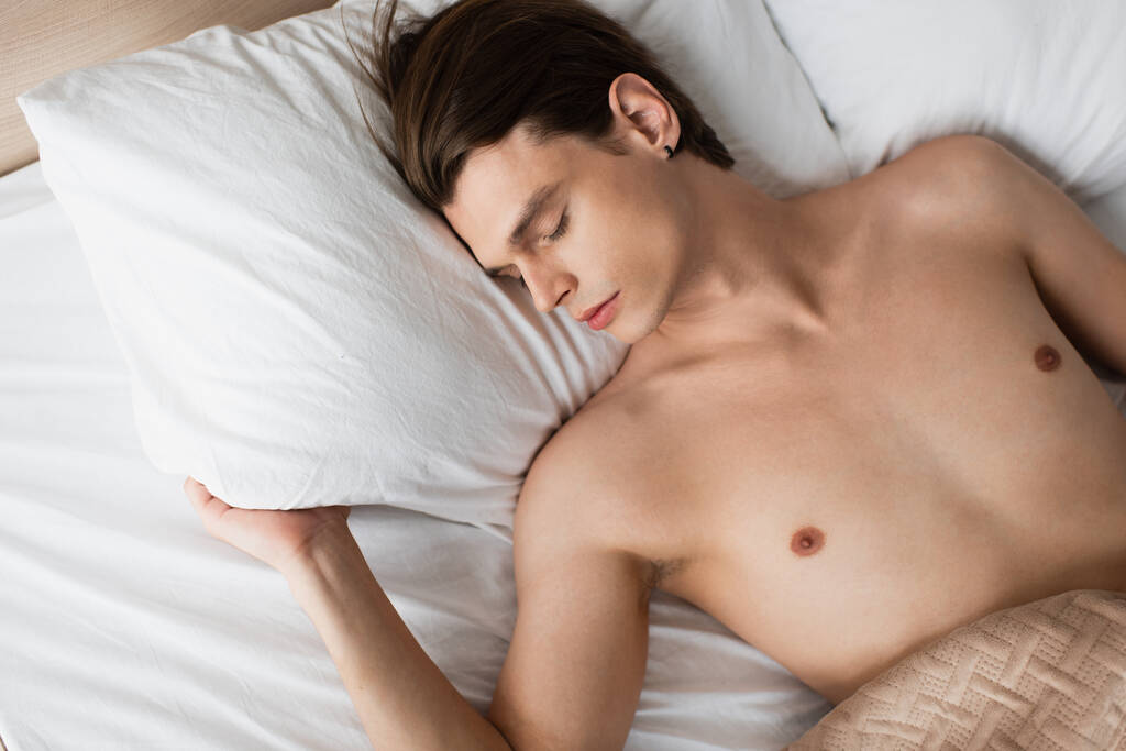 vista dall'alto di camicetta transgender uomo dormire a letto a casa - Foto, immagini