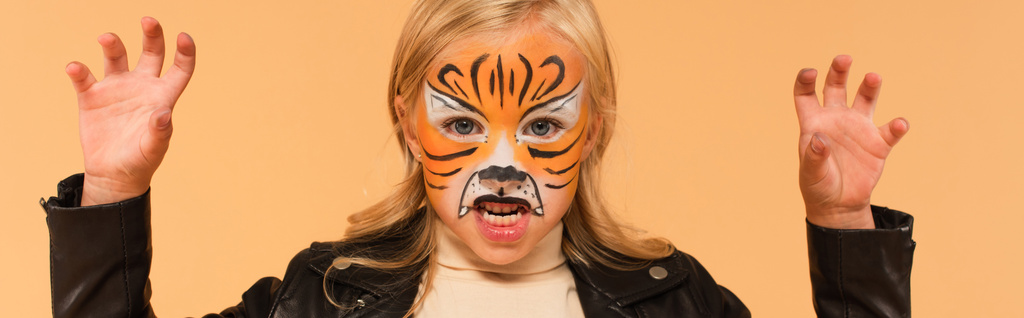 lány tigris arc festmény morgó és mutatja ijesztő gesztus elszigetelt bézs, banner - Fotó, kép