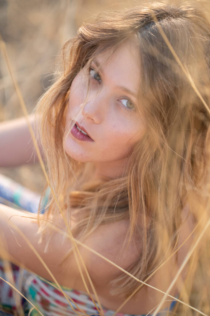 Mujer hermosa joven de aspecto natural con ojos de avellana posando en los campos, sin post edición  - Foto, imagen