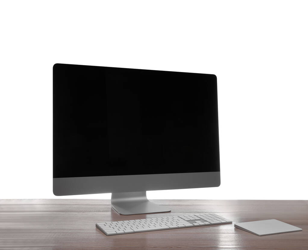 Moderní počítač s prázdnou obrazovkou monitoru a periferiemi na dřevěném stole na bílém pozadí - Fotografie, Obrázek