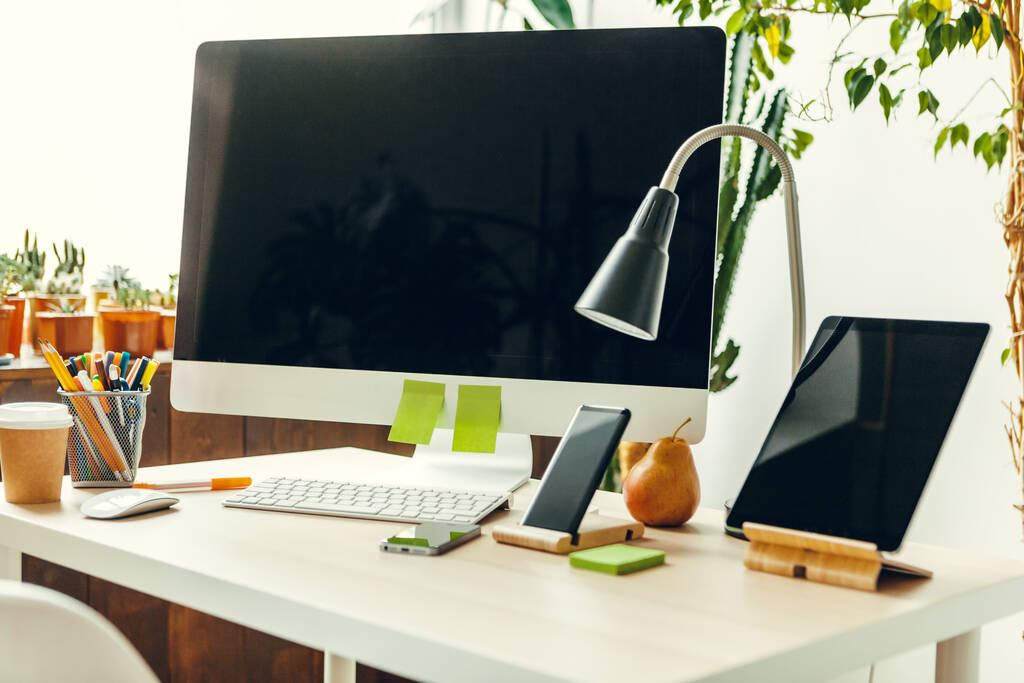 オフィスやホームワークスペース。電源とオフィステーブルの上に黒い画面でコンピュータモニタ - 写真・画像