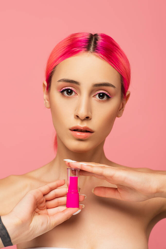 Nuori nainen värjätyt hiukset tilalla kirkas huulipuna eristetty vaaleanpunainen  - Valokuva, kuva