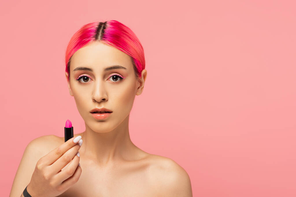 young woman with colorful hair holding bright lipstick isolated on pink  - Photo, Image