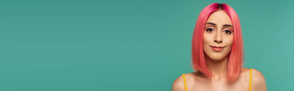 hezká mladá žena s růžovými barvenými vlasy s úsměvem izolované na modré, banner - Fotografie, Obrázek
