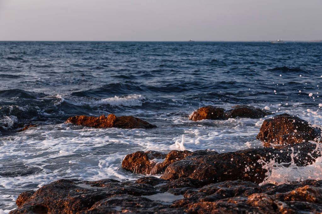 海岸沿いの石。日没のロッキービーチ。自然背景. - 写真・画像
