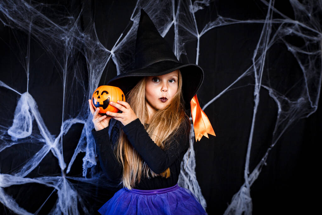 Kleines Mädchen im Hexen-Halloween-Kostüm hat Spaß. Süßes oder Saures - Foto, Bild