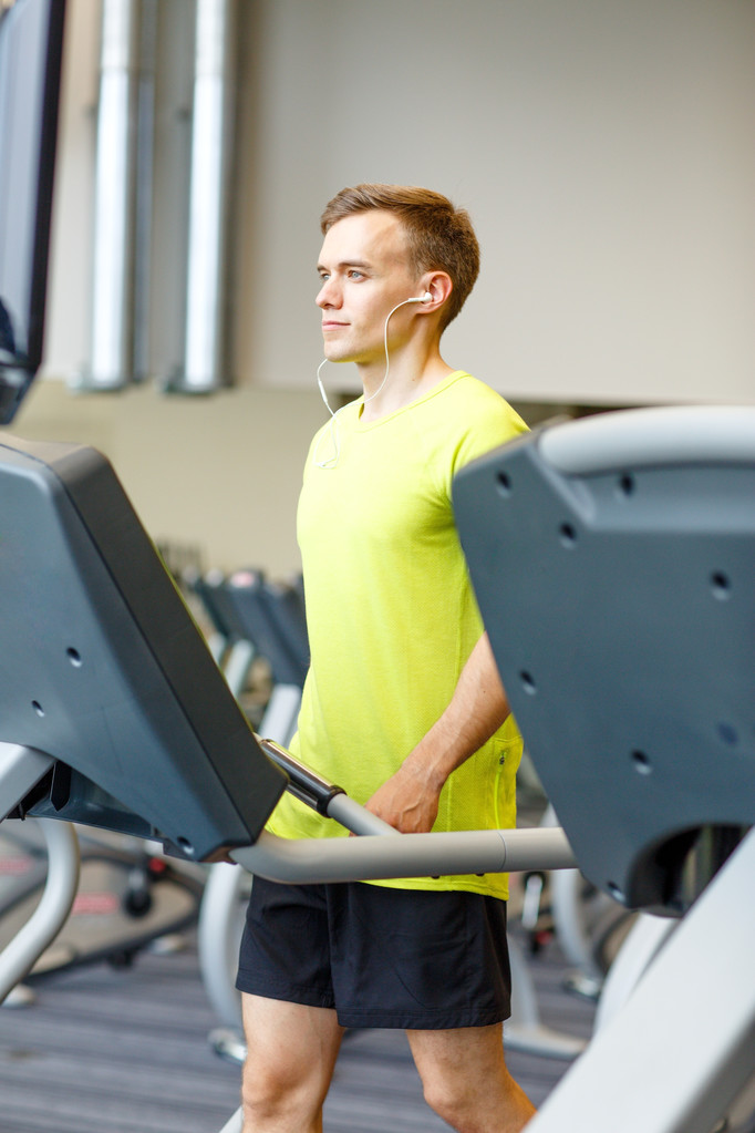 człowiek z smartphone ćwiczenia na bieżni w siłowni - Zdjęcie, obraz