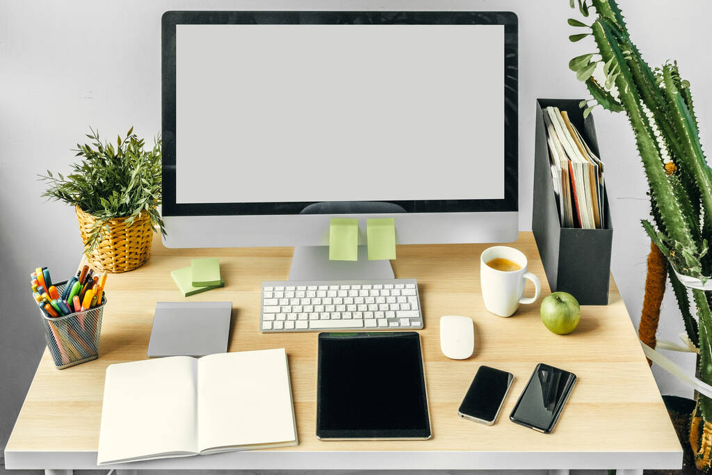 Monitor de computadora con pantalla blanca maqueta en la mesa de la oficina con suministros - Foto, Imagen