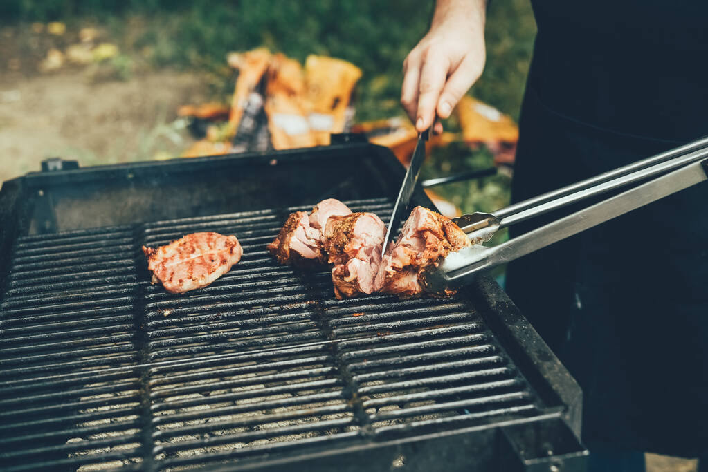 Grillezett sertés tekercs. A szakács felszeletel egy darab grillezett húst.. - Fotó, kép