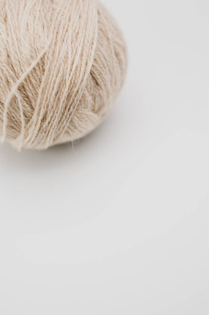 Metin boşluğu olan beyaz bir arkaplan üzerinde izole edilmiş bej iplik dikey bir çekim - Fotoğraf, Görsel