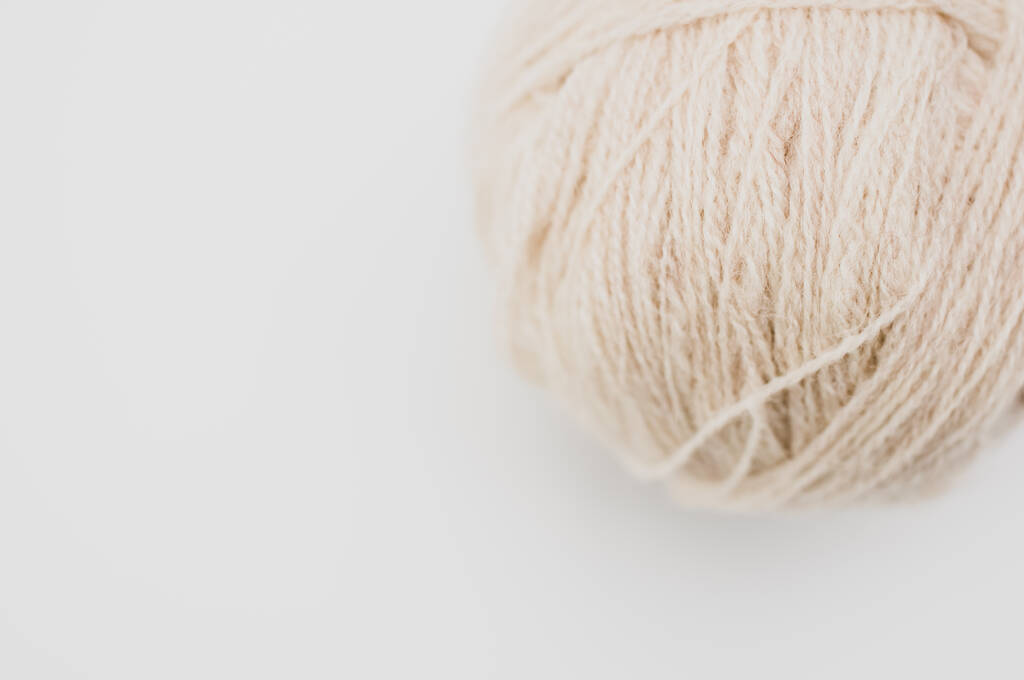 A vertical shot of isolated beige yarn on a white background with text space - Photo, Image