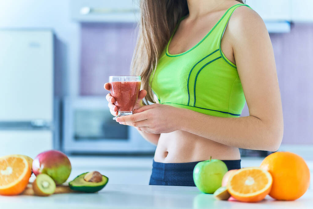 Fitness female in sportswear drinks a fresh fruit smoothie for losing weight. Vitamin diet drinks for healthy eating       - Photo, Image