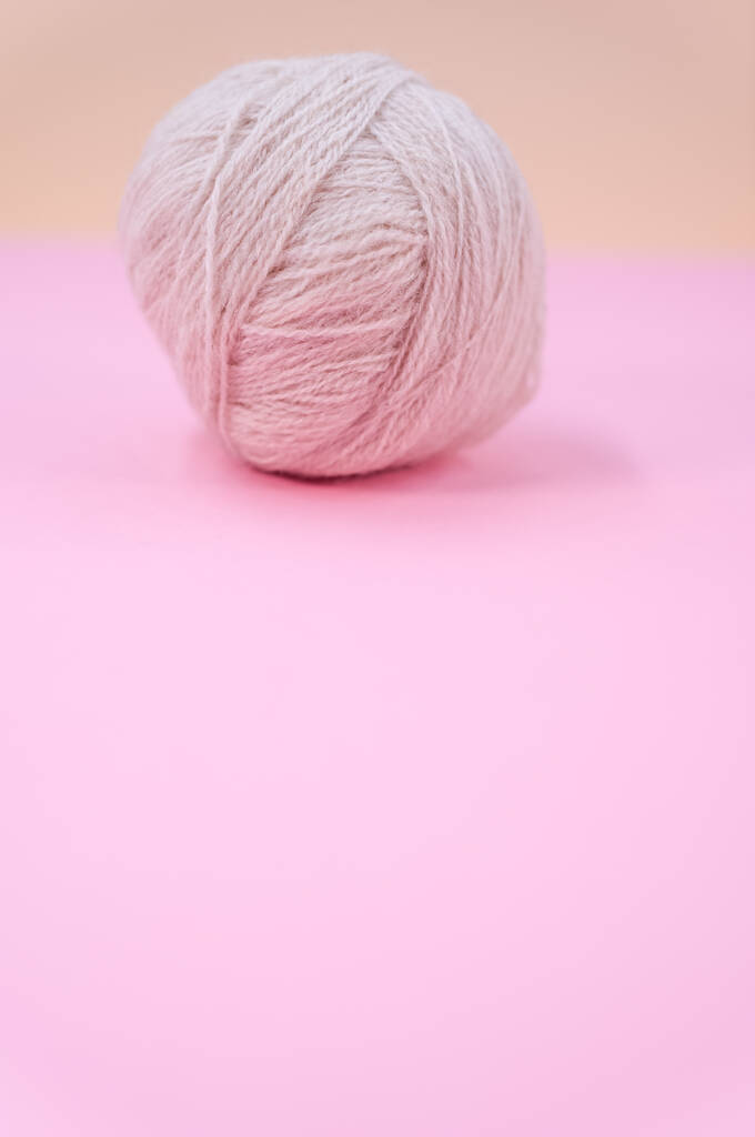 Een verticaal shot van geïsoleerd beige garen op een roze achtergrond met tekstruimte - Foto, afbeelding
