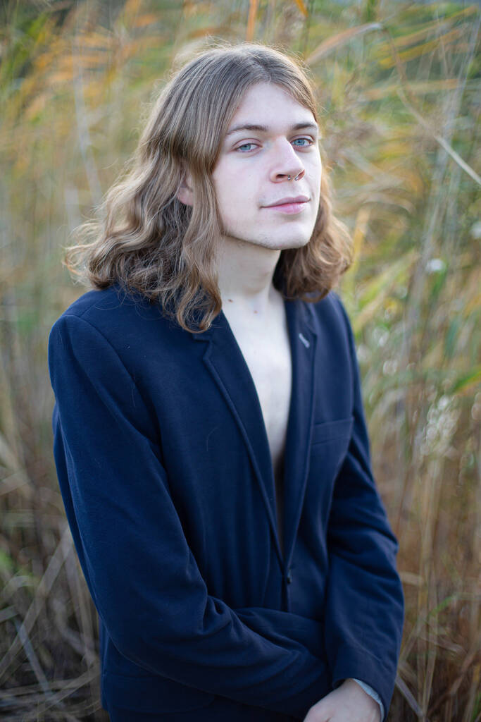 Homem branco com cabelos longos em roupas escuras na natureza - Foto, Imagem
