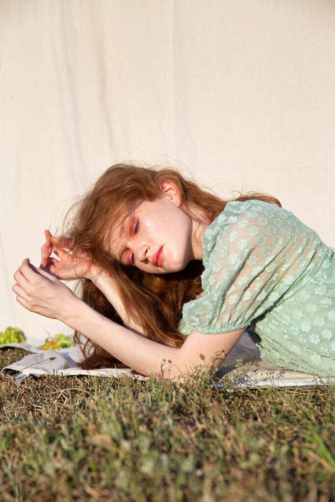Jeune fille en robe verte sur herbe verte aux cheveux roux - Photo, image