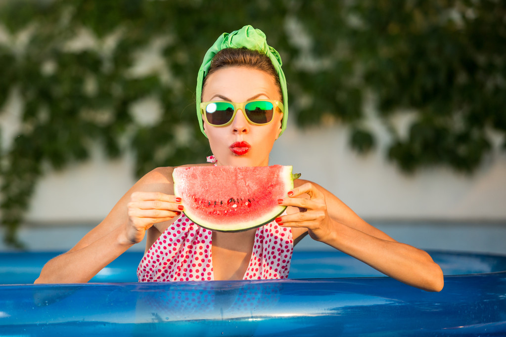 Modelo de beleza com melancia na piscina
 - Foto, Imagem