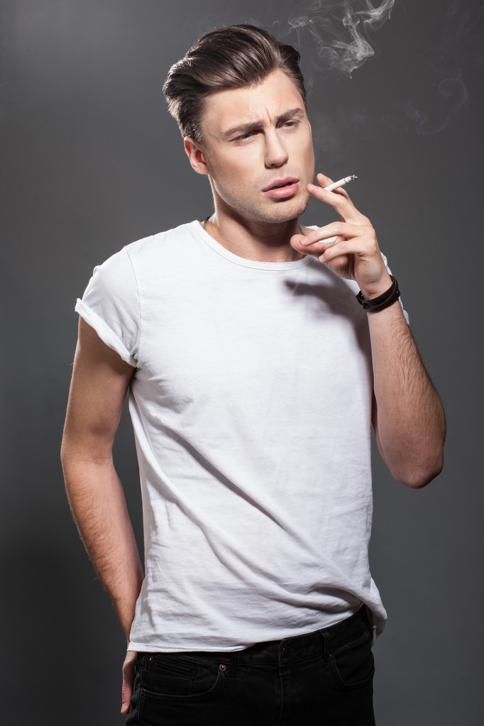 przystojny, młody człowiek palenia papierosów - Zdjęcie, obraz